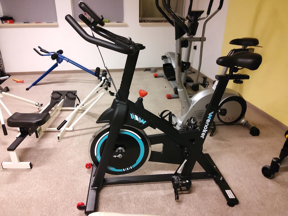 A well-organized small apartment home gym with a Wenoker exercise bike and neatly stored fitness equipment, demonstrating efficient use of limited space.