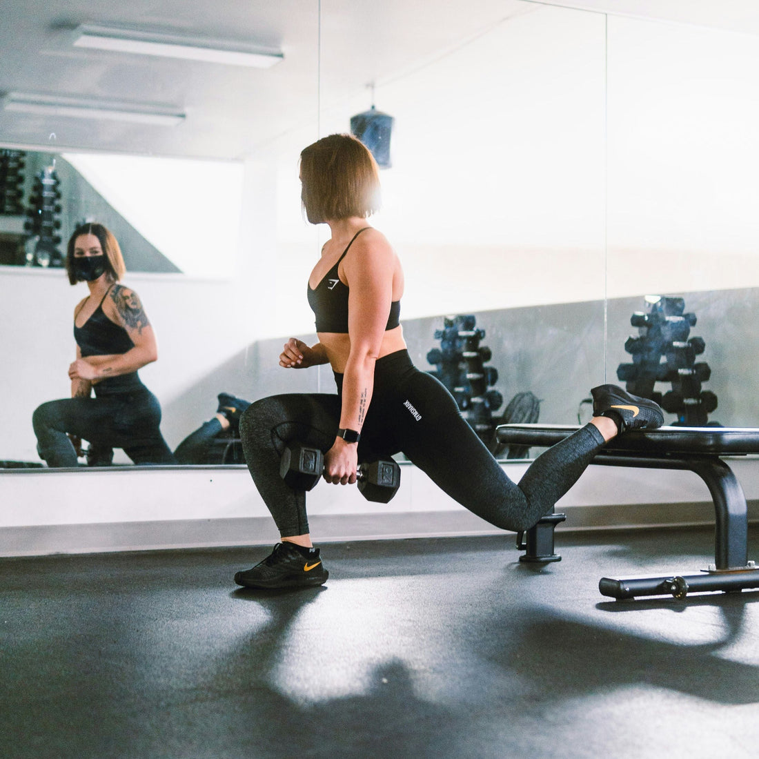 A beginner at the gym looking in the mirror, thinking about how to start cutting for fat loss.