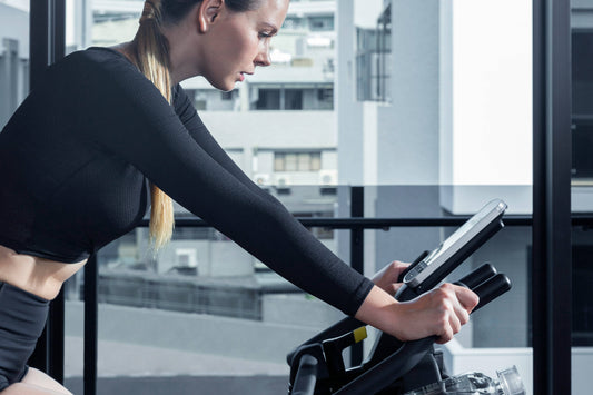 Person smiling while monitoring heart rate zones on a Wenoker Exercise Bike at home