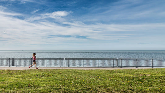 A runner enjoying a scenic trail run, demonstrating proper running form and engagement of full body muscles.